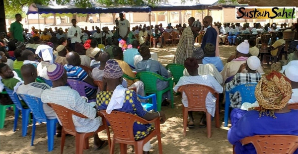 This image shows a group of people sitting in chairs facing a speaker